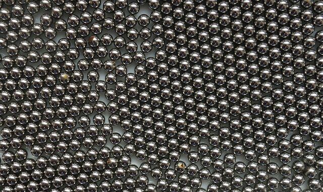 Grafika przedstawia stalowe kulki na białym tle.
