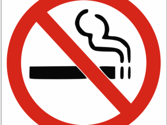 Grafika przedstawia znak zakazu palenia. Znak jest w kształcie koła. Obwódka koła jest w kolorze czerwonym. W środku znaku znajduje się pozycji poziomej prostokąt. Po prawej stronie prostokąta umieszczone są dwie pionowe kreseczki. Nad tymi kreskami unosi się chmura dymu. Grafika w środku obrazuje paląc się papieros. Z ukosa przez środek koła biegnie czerwona linia przekreślająca symbol papierosa.